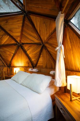 a bedroom with a bed in a yurt at Los Pinos EcoHotel in Hobo