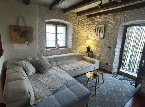 a living room with a couch in a stone wall at Istrian Private Garden Oasis in Žminj