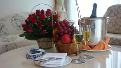 a table with wine glasses and a basket of fruit and flowers at Hanoi Daewoo Hotel in Hanoi