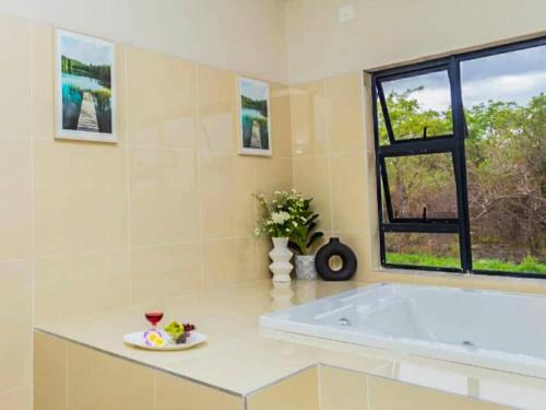 a large white bathroom with a tub and a window at Tree Tops Game Resort in Magomba