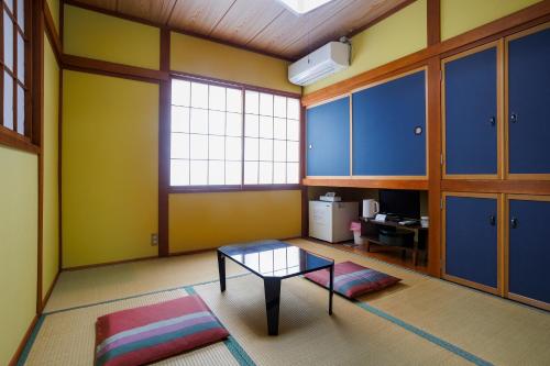 a living room with a glass table and blue cabinets at Kappa Tengoku in Hakone