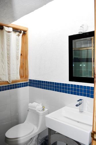 a bathroom with a white toilet and a sink at Cabañas el Chalet in Morelia