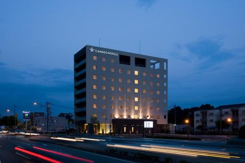 a lit up building on a city street at night at Candeo Hotels Kikuyo Kumamoto Airport in Kikuyo