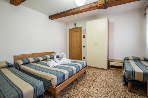 a bedroom with two beds with white towels on them at Casa Sant'Andrea in Venice