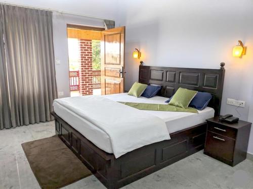 a bedroom with two beds and a window at Corbett Krishna Inn in Belparāo