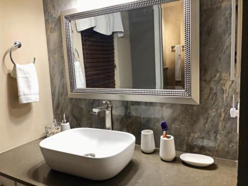 ein Badezimmer mit einem weißen Waschbecken und einem Spiegel in der Unterkunft Davis Isle Private Resort Luxury in Orlando