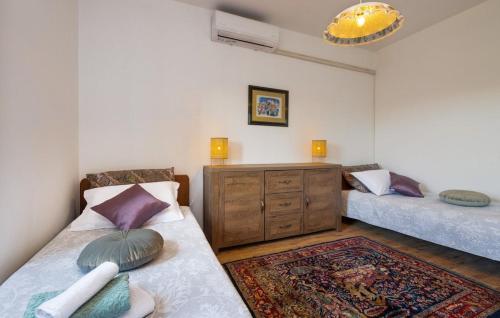 a bedroom with two beds and a dresser in it at Villa Maria in Krnica