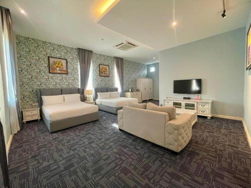 a living room with two couches and a flat screen tv at Casa Bianca in Kluang