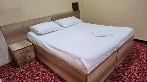 a bed with two white pillows on it in a room at Sitora in Chirchiq
