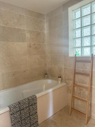 a bath tub in a bathroom with a window at Maison individuelle piscine extérieure in Port-Saint-Louis-du-Rhône