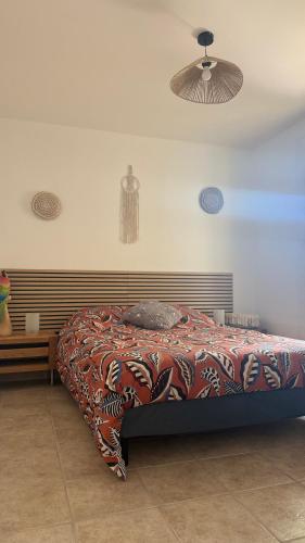 a bedroom with a bed with a colorful blanket at Maison individuelle piscine extérieure in Port-Saint-Louis-du-Rhône