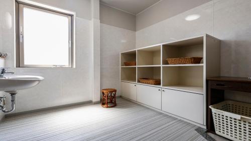 a white bathroom with a sink and a window at Suzuka Storia Hotel in Suzuka