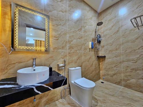 a bathroom with a sink and a toilet and a mirror at Serene Residence in Vientiane