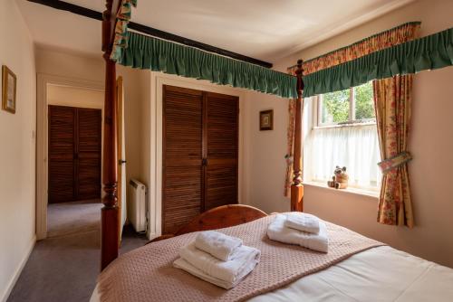 a bedroom with a bed with towels on it at Bramble Cottage in Wooler