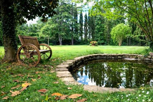 a bench sitting next to a pond in a park at Villa With Pool, Gym, Pond And Panoramic Views in Laterina