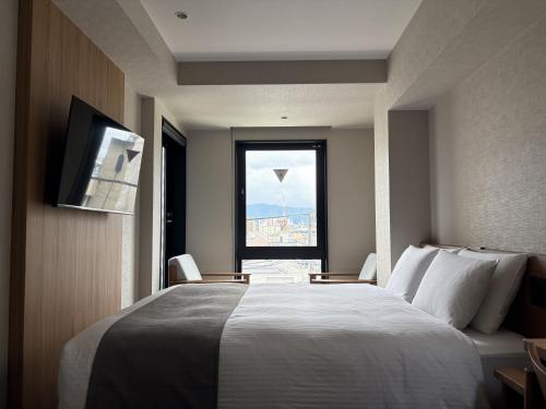 a hotel room with a large bed and a window at hotel bolam kyoto in Shimo-dachiyuuridōri