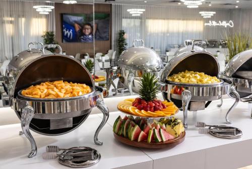 a buffet with three pans of food on a table at Magic Moment Resort & Kids Club, Dazzler Select by Wyndham in Kissimmee