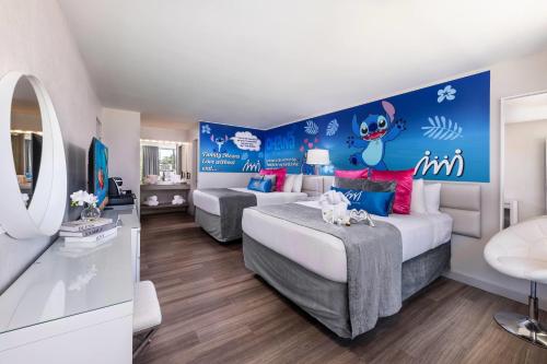 a hotel room with two beds and a tv at Magic Moment Resort & Kids Club, Dazzler Select by Wyndham in Kissimmee
