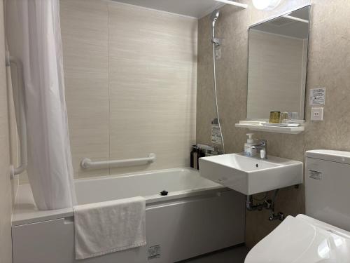 a bathroom with a sink and a tub and a toilet at hotel bolam kyoto in Shimo-dachiyuuridōri