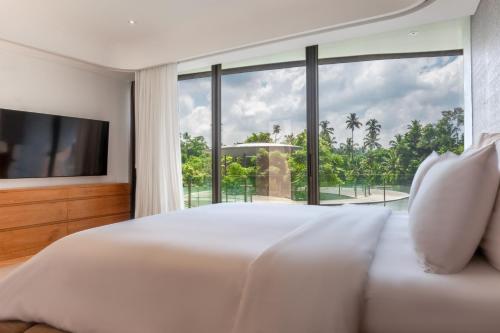 a bedroom with a large bed and a large window at Bumi Kinar Skylight in Ubud