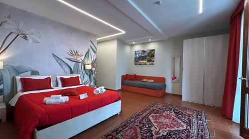 a bedroom with a red bed and a couch at Villa Zufrò in Vibo Valentia