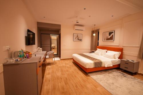 a bedroom with a bed and a desk in it at Hotel California in Bangalore