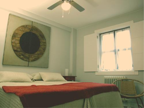 1 dormitorio con 1 cama y ventilador de techo en Casa Rota By KubiK, en Cáceres