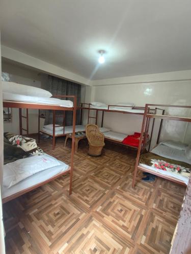 a room with four bunk beds and a wooden floor at Sajjus Riverside Retreat in Manāli