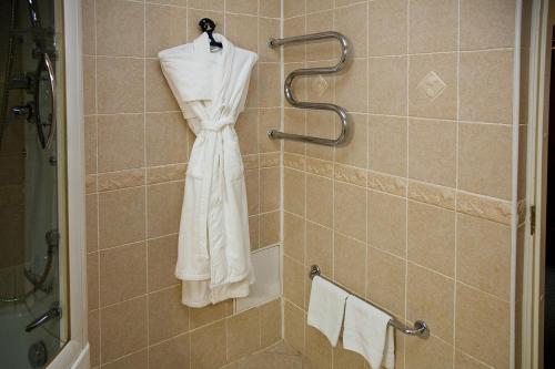 a white robe is hanging in a shower at Taganskaya Hotel in Yekaterinburg