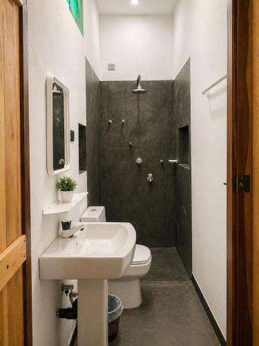 a bathroom with a sink and a toilet and a shower at One FS Hotel Arugambay in Arugam Bay