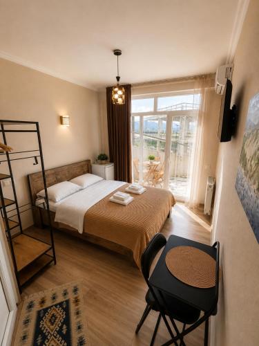 a bedroom with a bed and a chair and a window at Hotel Marioni in Tbilisi City