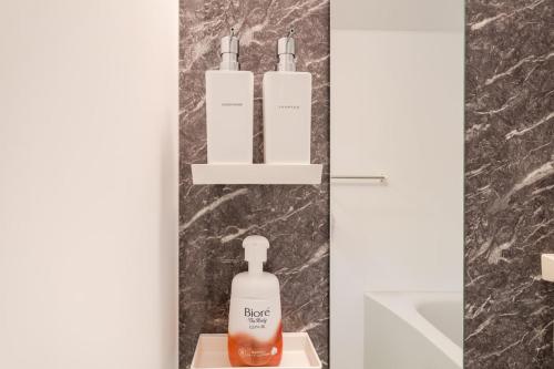 a bathroom with two bottles of soap on a shelf at Value residence Kugai 3A in Miyako-jima