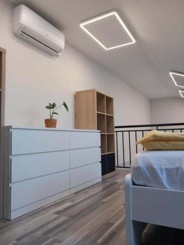 a bedroom with a bed and a dresser at Gemini Apartman in Esztergom