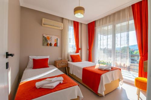 two beds in a room with a window at Sureyya Hotel By Kalipso in Oludeniz