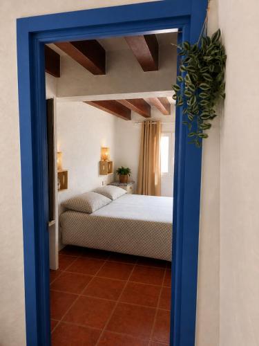 a bedroom with a bed and a blue doorway at La Casita Vertical casco histórico de Segorbe in Segorbe