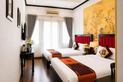 a hotel room with two beds and a window at Hanoi Sena Hotel & Travel in Hanoi