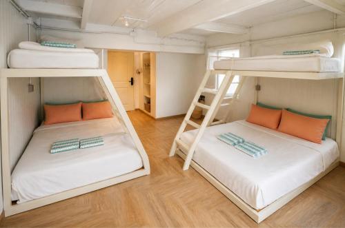 two bunk beds in a small room with a ladder at Bangkok Group Bunk Hotel Khaosan in Bangkok
