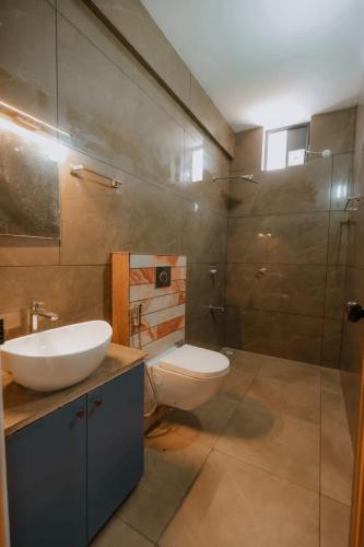 a bathroom with a toilet and a sink and a shower at River Side Paradise By Greenleaves Munnar in Anachal