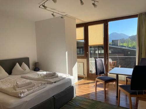 a bedroom with a bed and a table with a view at Appartements Domizil in Kaprun