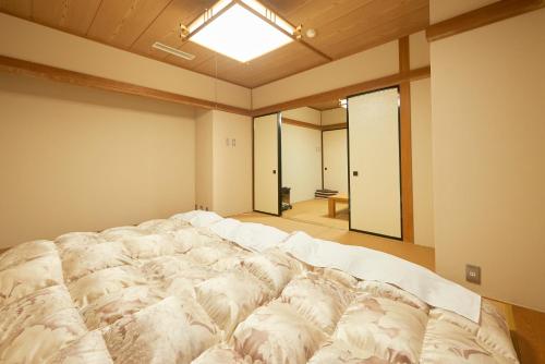 a large white bed in a room with a window at Select inn Iwaki Ekimae in Iwaki