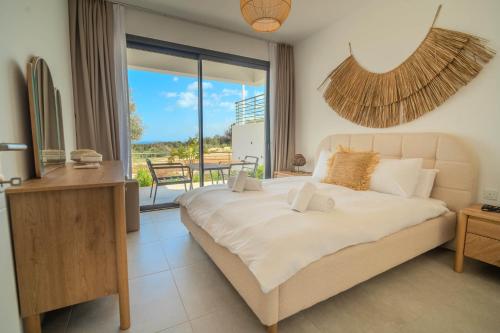 a bedroom with a large bed and a balcony at Sun Valley Resort & Residency in Kyrenia