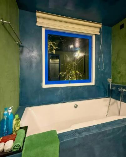 a bathroom with a bath tub with a window at Refuge Boutique Villa in Hikkaduwa