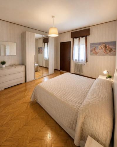a bedroom with a large white bed in a room at APPARTAMENTI LA CONCHIGLIA in Caorle