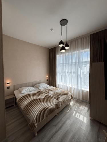 a bedroom with a bed and a large window at Miva in Qusar