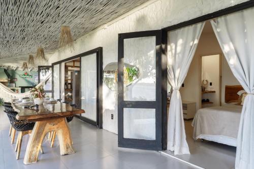 a room with a door and a bed and a table at Pipa Sunset Home in Pipa