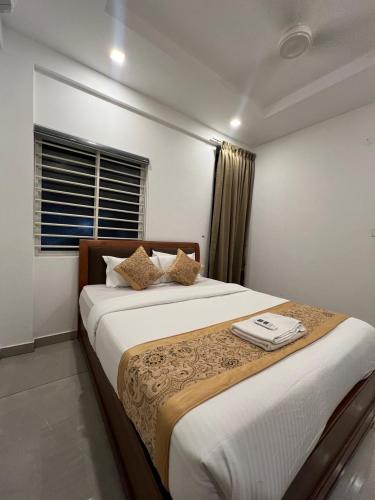 a bedroom with a large bed in a room at Orbis Rooms & Apartments in Kakkanad