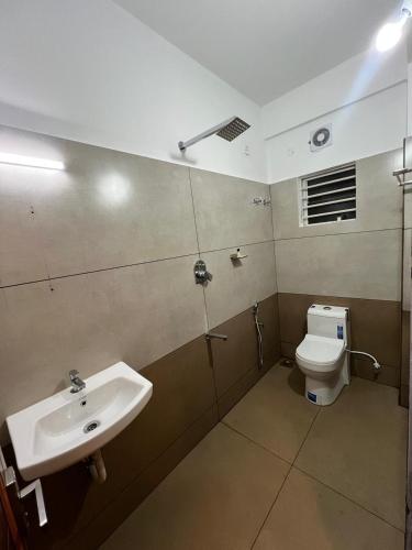 a bathroom with a sink and a toilet at Orbis Rooms & Apartments in Kakkanad