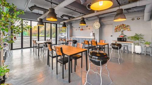 a restaurant with wooden tables and chairs and windows at Baradeon Bada Pension, Yangyang in Yangyang