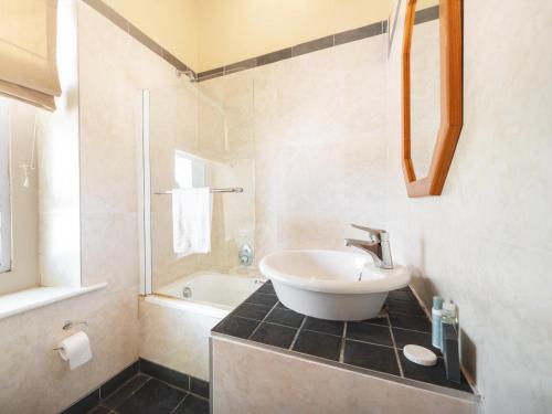 a bathroom with a sink and a bath tub at Oak lodge Guest House in Grahamstown