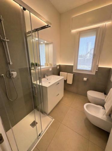 a bathroom with a shower and a sink and a toilet at Residence Antares - Agenzia Cocal in Caorle